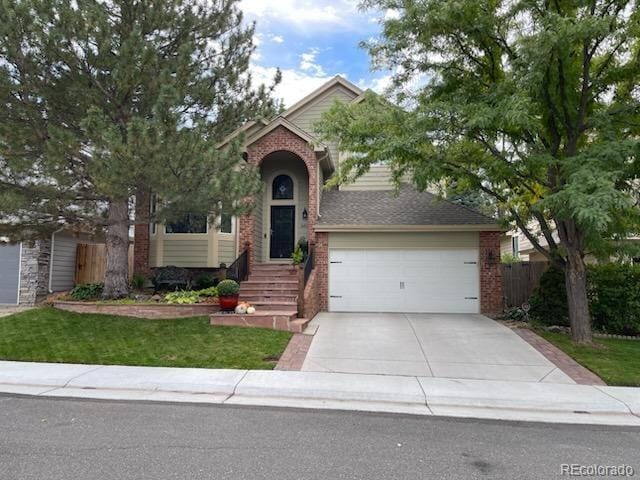 8012 W 78th Cir, Arvada, CO 80005 - view of front of house with brick siding, concrete driveway, and a garage
