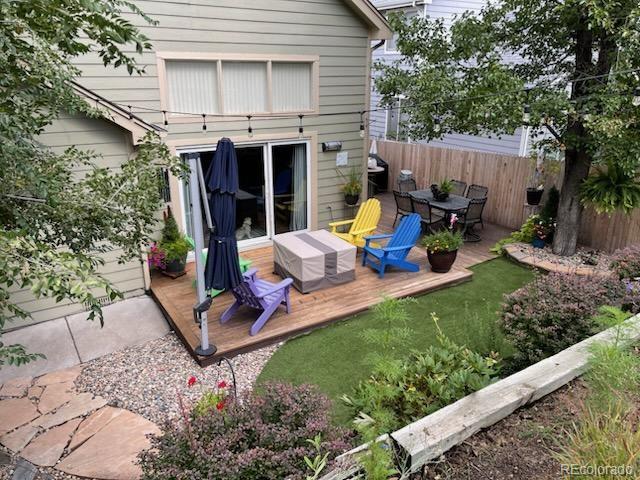 8012 W 78th Cir, Arvada, CO 80005 - back of house featuring a wooden deck and outdoor dining area
