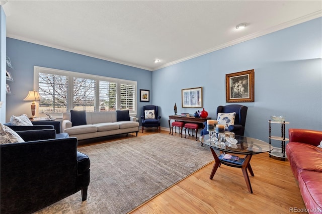 living area featuring baseboards, light wood-style flooring, and ornamental molding