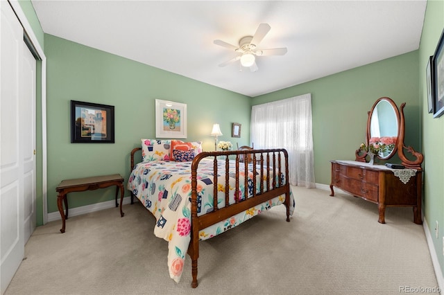 carpeted bedroom with a closet, baseboards, and a ceiling fan