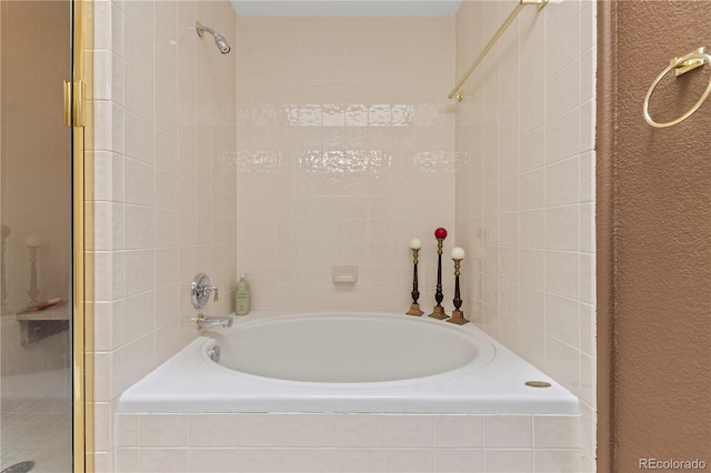 bathroom featuring tiled tub and a stall shower