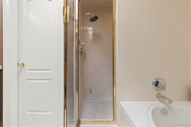 bathroom with a tub and a stall shower