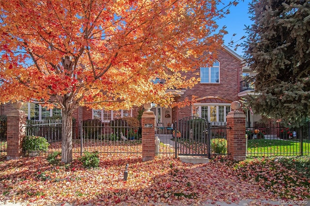 obstructed view of property featuring a fenced front yard, brick siding, and a gate