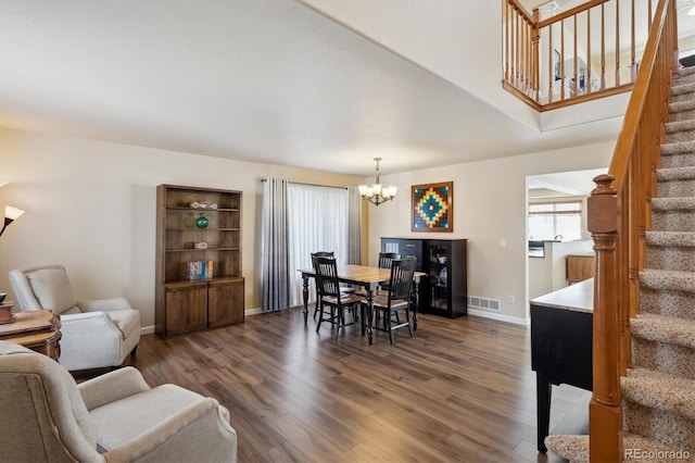 dining space featuring a healthy amount of sunlight, a chandelier, and dark hardwood / wood-style flooring