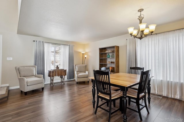 dining area featuring dark hardwood / wood-style flooring and a chandelier