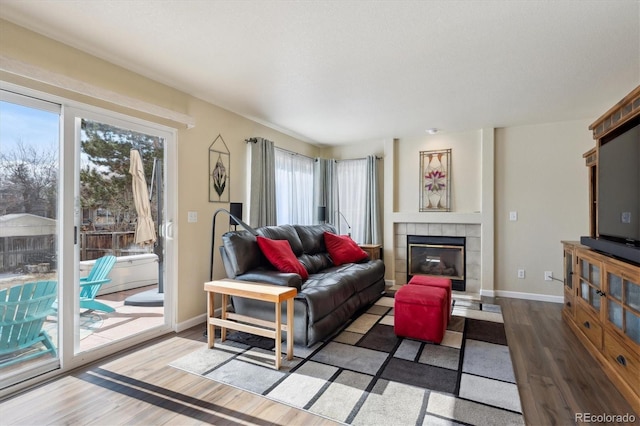 living room featuring a tiled fireplace and hardwood / wood-style flooring