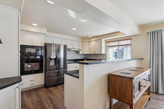 kitchen featuring dark wood-type flooring, black appliances, white cabinets, decorative backsplash, and kitchen peninsula