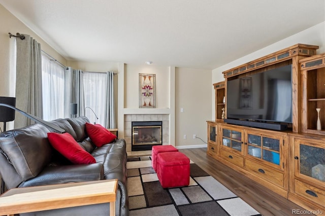 living room with dark wood-type flooring and a fireplace