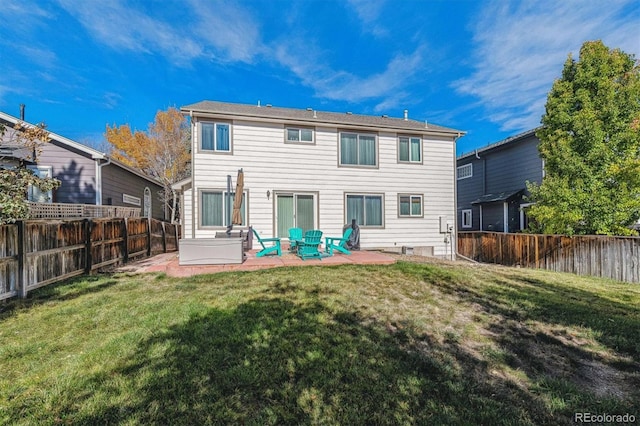 back of property with a yard and a patio area