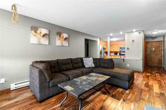 living room featuring wood-type flooring, a textured ceiling, and baseboard heating