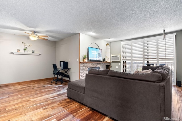 living room with a textured ceiling and light wood-type flooring