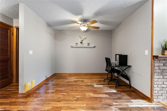 office space with ceiling fan, a textured ceiling, and light hardwood / wood-style flooring