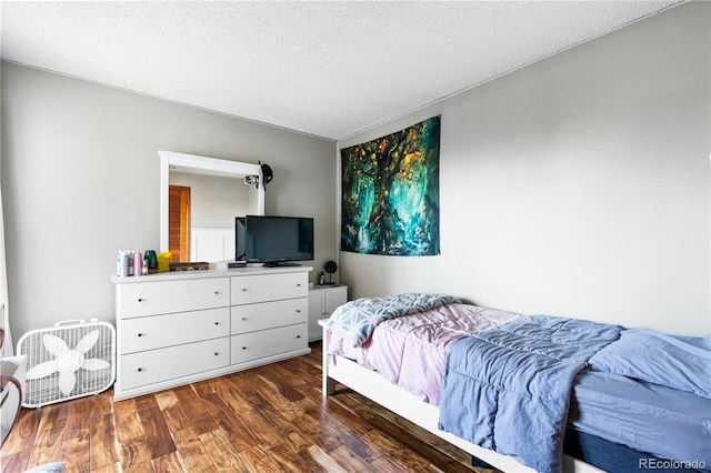 bedroom featuring dark hardwood / wood-style floors and a textured ceiling