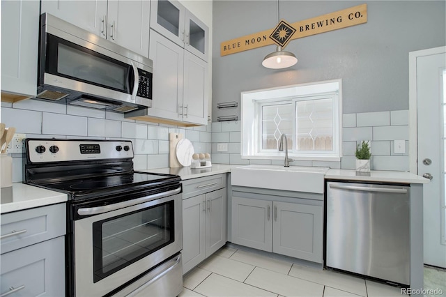 kitchen featuring pendant lighting, appliances with stainless steel finishes, sink, and decorative backsplash