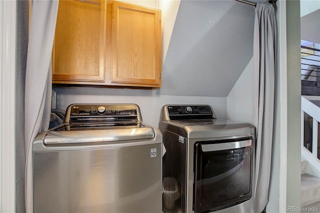 clothes washing area with washer and dryer and cabinets