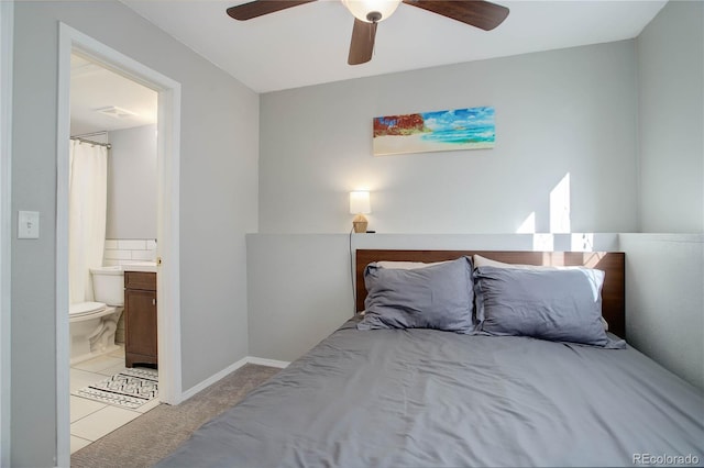 bedroom featuring light carpet, ensuite bath, and ceiling fan