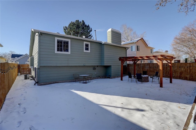 snow covered property featuring a pergola and an outdoor fire pit