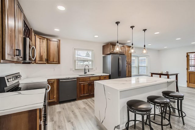 kitchen with a wealth of natural light, appliances with stainless steel finishes, sink, and a kitchen island