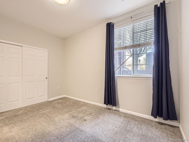 unfurnished bedroom featuring carpet floors and a closet