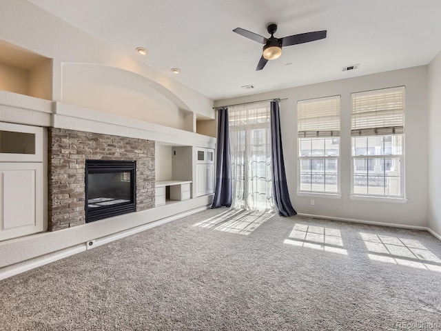 unfurnished living room featuring ceiling fan, light colored carpet, and a fireplace