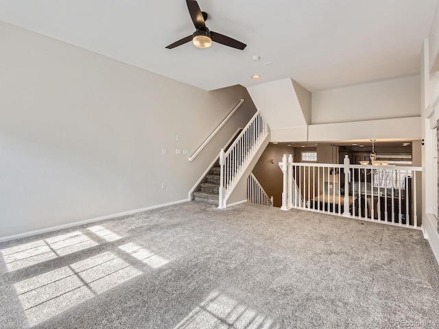 unfurnished living room with ceiling fan and carpet