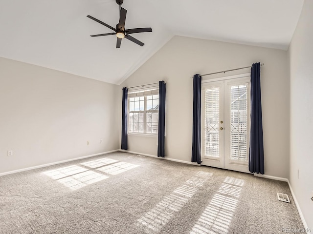 empty room with french doors, ceiling fan, lofted ceiling, and light carpet