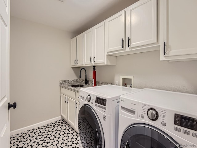 washroom with cabinets, sink, and washer and dryer