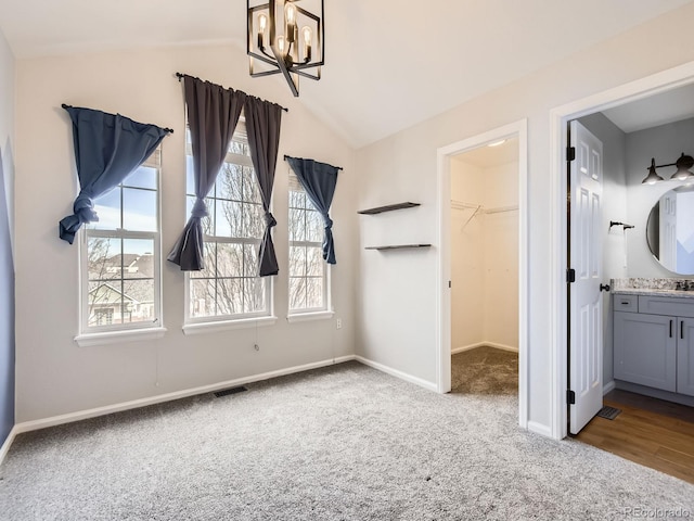 interior space featuring lofted ceiling, connected bathroom, light carpet, a spacious closet, and a closet