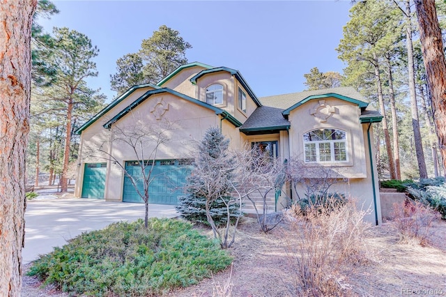 view of front of house with concrete driveway, an attached garage, and stucco siding