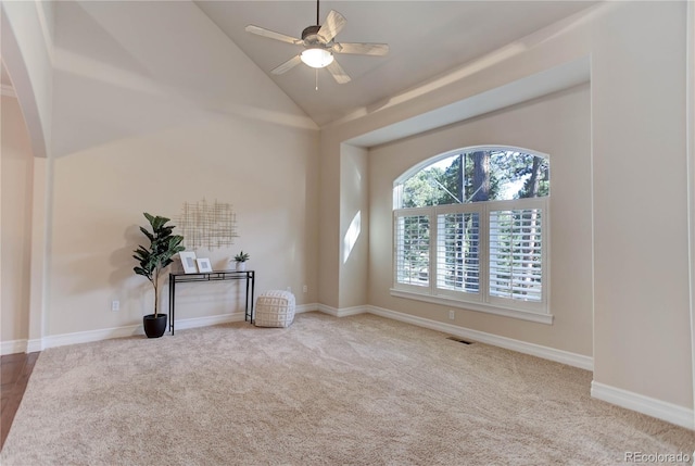 spare room with visible vents, baseboards, ceiling fan, carpet, and high vaulted ceiling