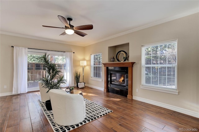 living area with hardwood / wood-style flooring, baseboards, crown molding, and a tile fireplace