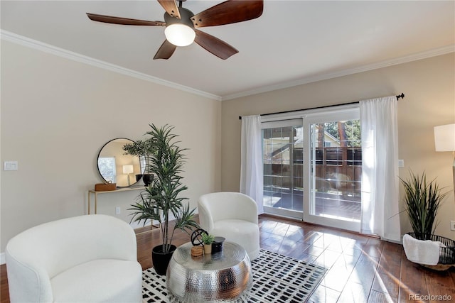 living area featuring ornamental molding, wood finished floors, and a ceiling fan