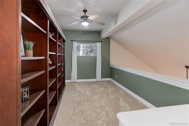 spacious closet with a ceiling fan, carpet, and vaulted ceiling with beams