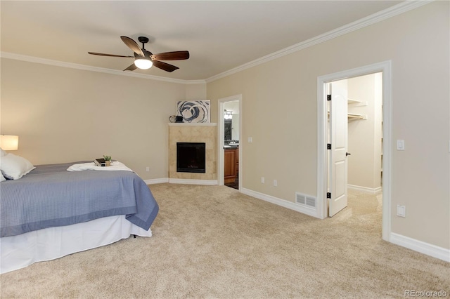 carpeted bedroom with baseboards, visible vents, a tiled fireplace, and ornamental molding