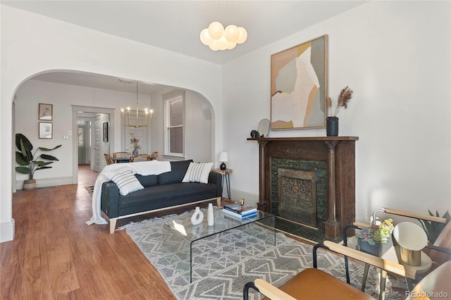 living room featuring a notable chandelier, hardwood / wood-style floors, and a high end fireplace