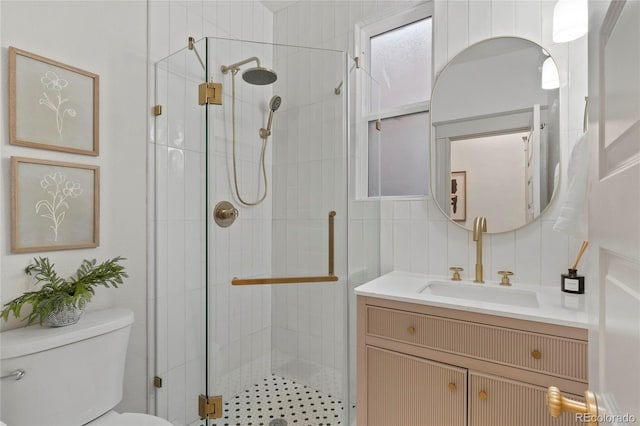 bathroom with toilet, a shower with door, vanity, and tile walls