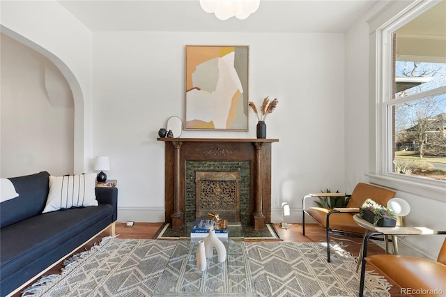 sitting room with a high end fireplace and hardwood / wood-style flooring