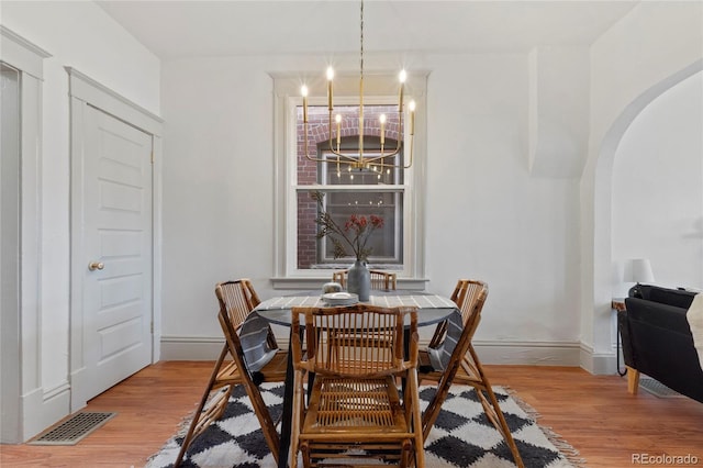 dining area featuring hardwood / wood-style floors and a chandelier