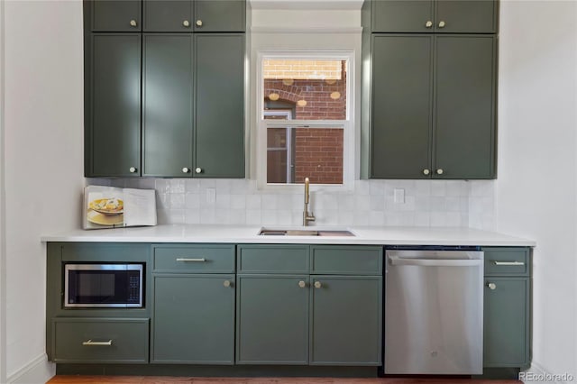 kitchen featuring appliances with stainless steel finishes, sink, and green cabinets