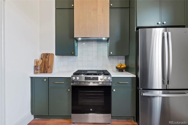 kitchen featuring green cabinets, backsplash, and appliances with stainless steel finishes