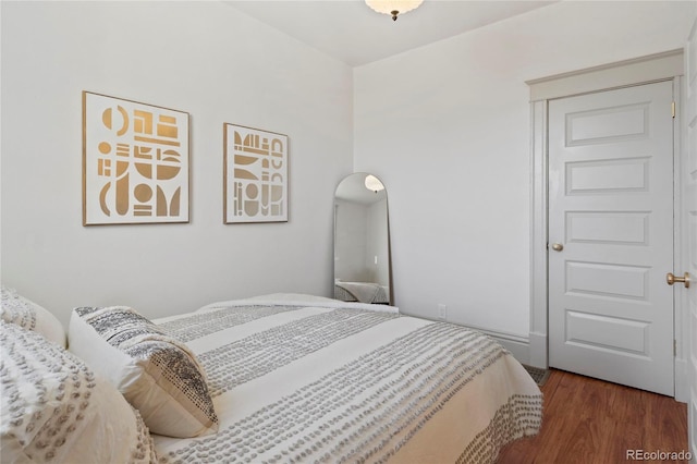 bedroom with dark hardwood / wood-style flooring