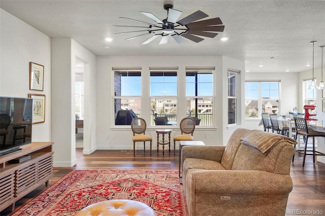 living area with baseboards, a ceiling fan, wood finished floors, and recessed lighting