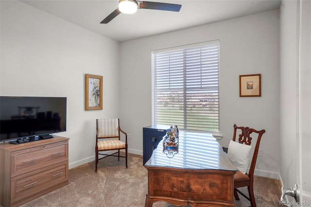 carpeted office space with ceiling fan and baseboards
