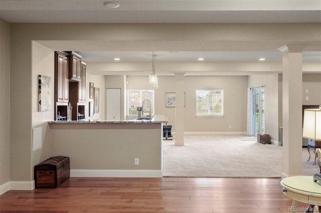 living room featuring baseboards, recessed lighting, light wood-style floors, and ornate columns