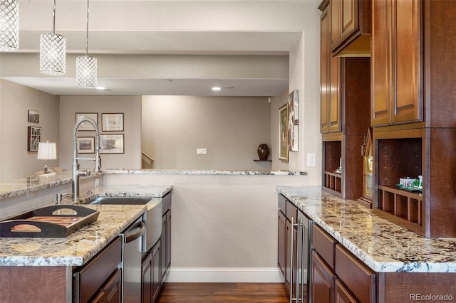 kitchen featuring dishwasher, a sink, dark wood-type flooring, light stone countertops, and baseboards