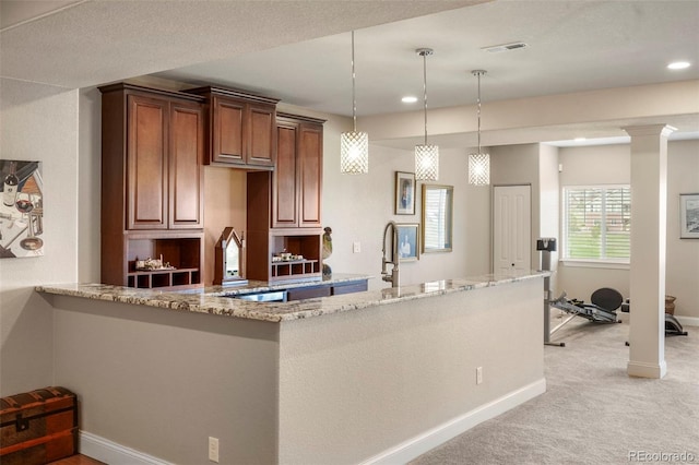 kitchen with light stone counters, visible vents, pendant lighting, baseboards, and light colored carpet