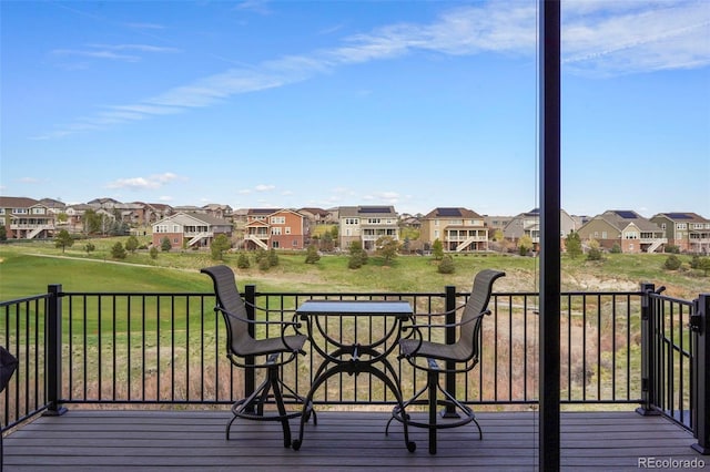 wooden terrace with a residential view and a lawn
