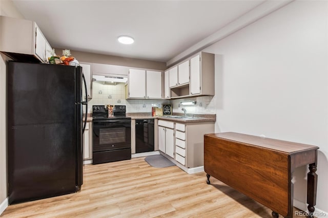 kitchen with sink, light hardwood / wood-style floors, decorative backsplash, white cabinets, and black appliances