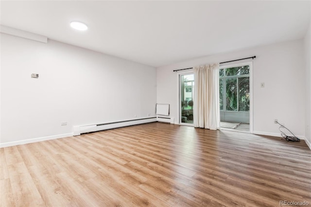 unfurnished room with light hardwood / wood-style floors and baseboard heating