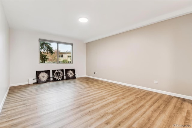 unfurnished living room featuring light hardwood / wood-style floors and a baseboard radiator